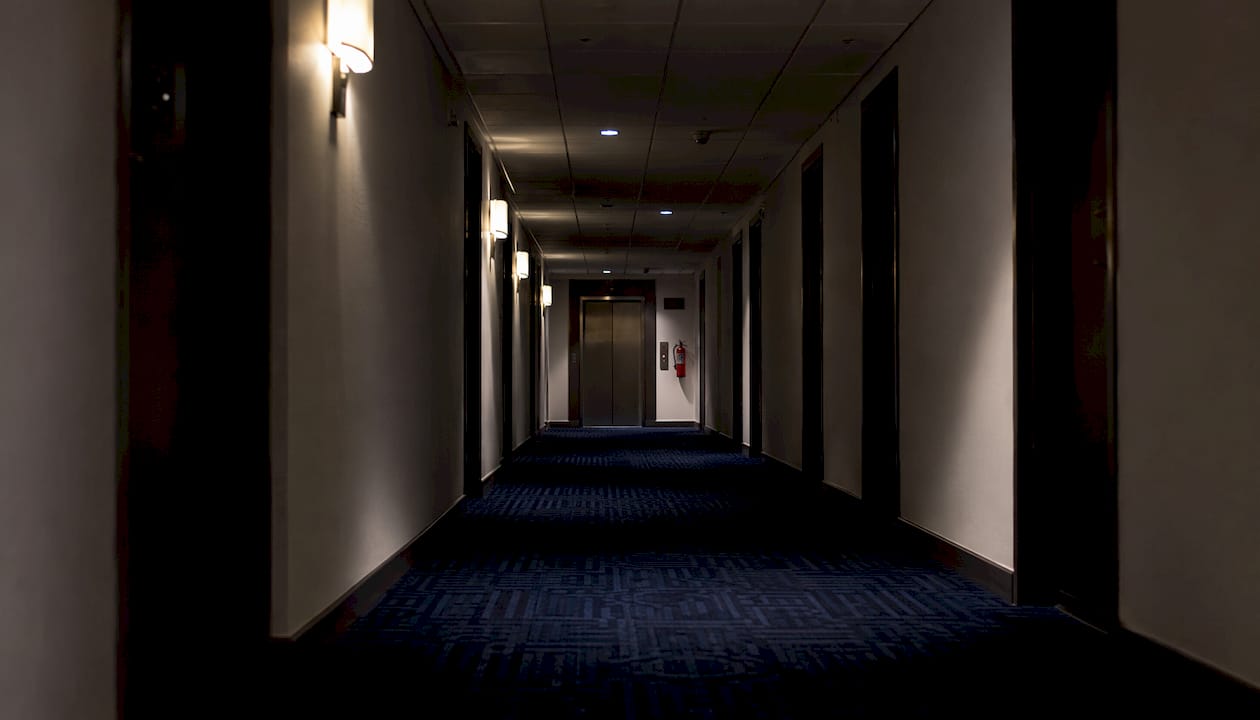 Empty dim hotel corridor with elevator door