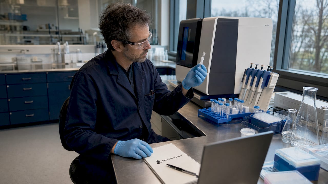 Technician handling DNA sample in forensic lab