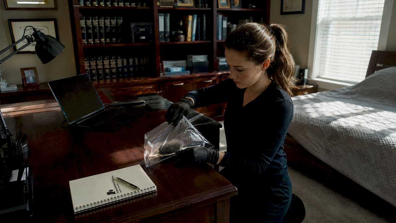 Hands placing plastic bag over hairbrush for evidence