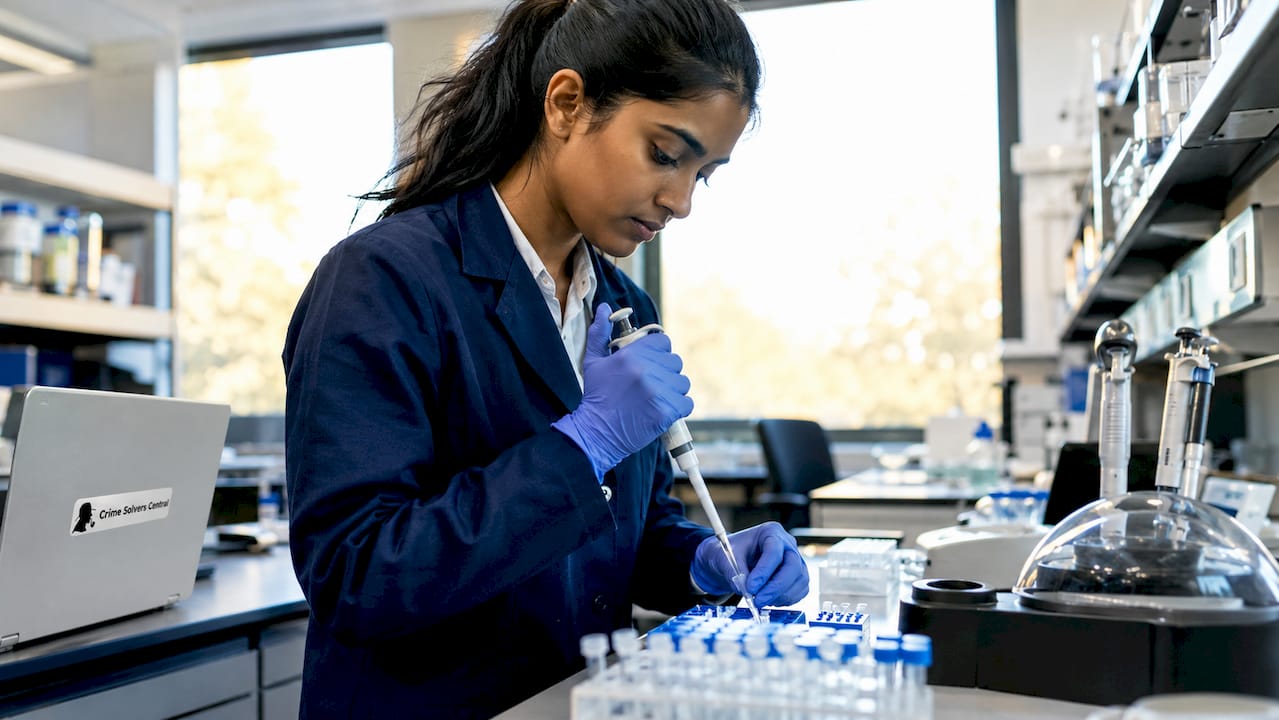Forensic scientist preparing DNA samples in lab